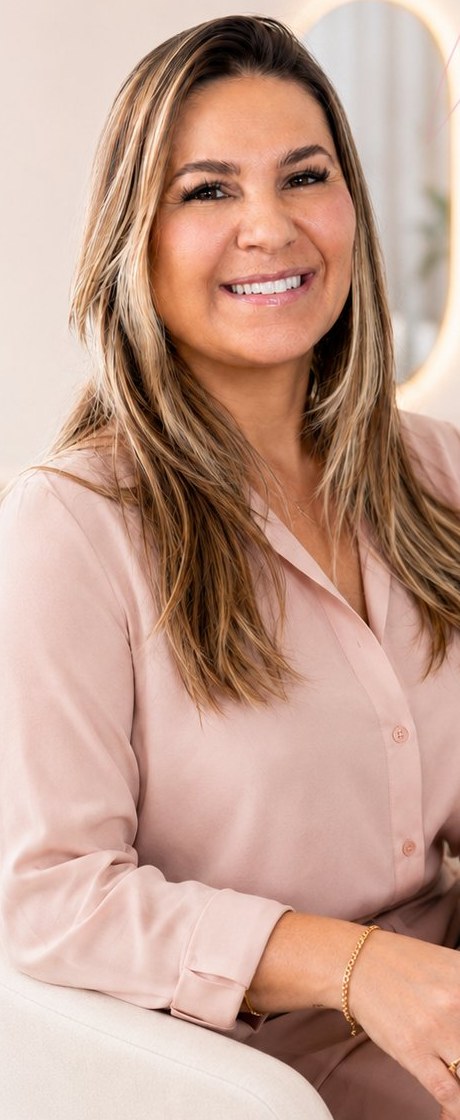 Pri Souza, idealizadora da Butterfly Clinic, sorrindo sentada em uma poltrona